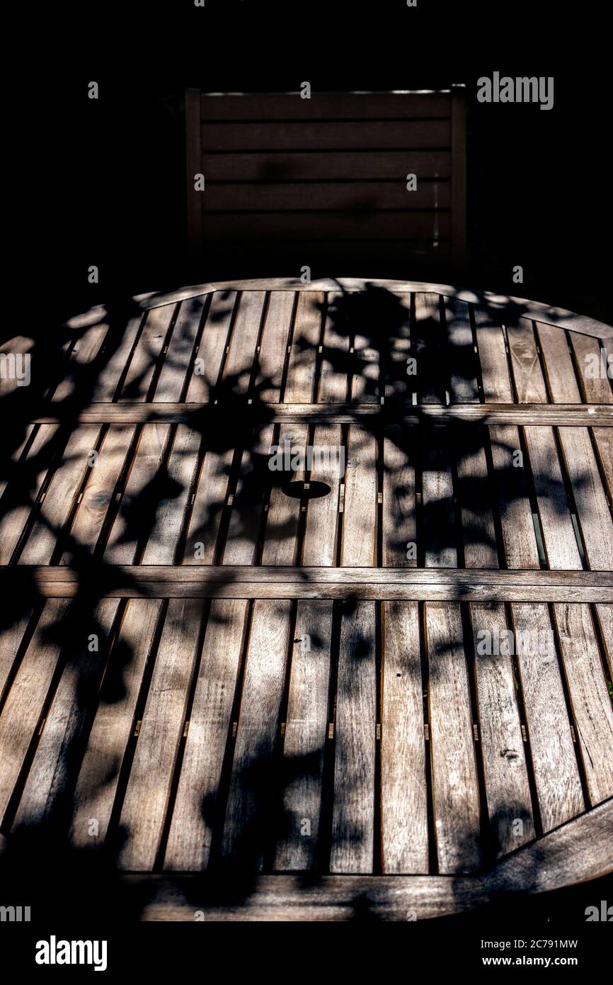 branches drop shadows on wooden garden table, Stock Photo