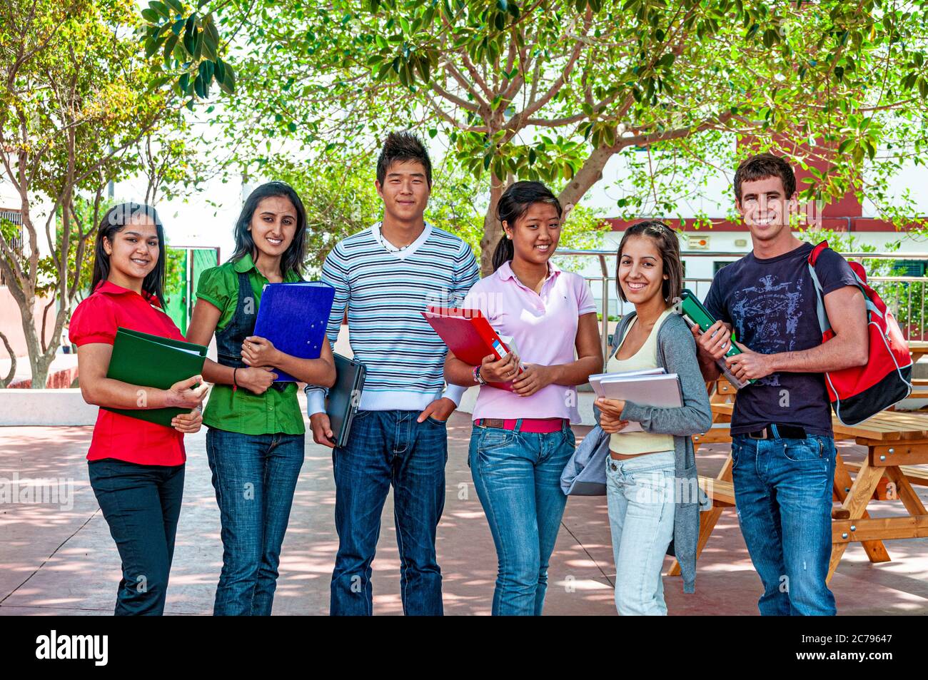 Multicultural Teenagers School group outdoors with study work folders smiling senior teenager students 15-17 years outside on school playground campus Stock Photo