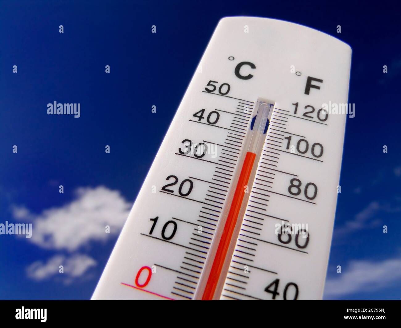 35C TEMPERATURE 93 F HEATWAVE  Temperature gauge rising red Concept Thermometer displays hot & sunny 93F degrees farenheit against a bright blue sky Stock Photo
