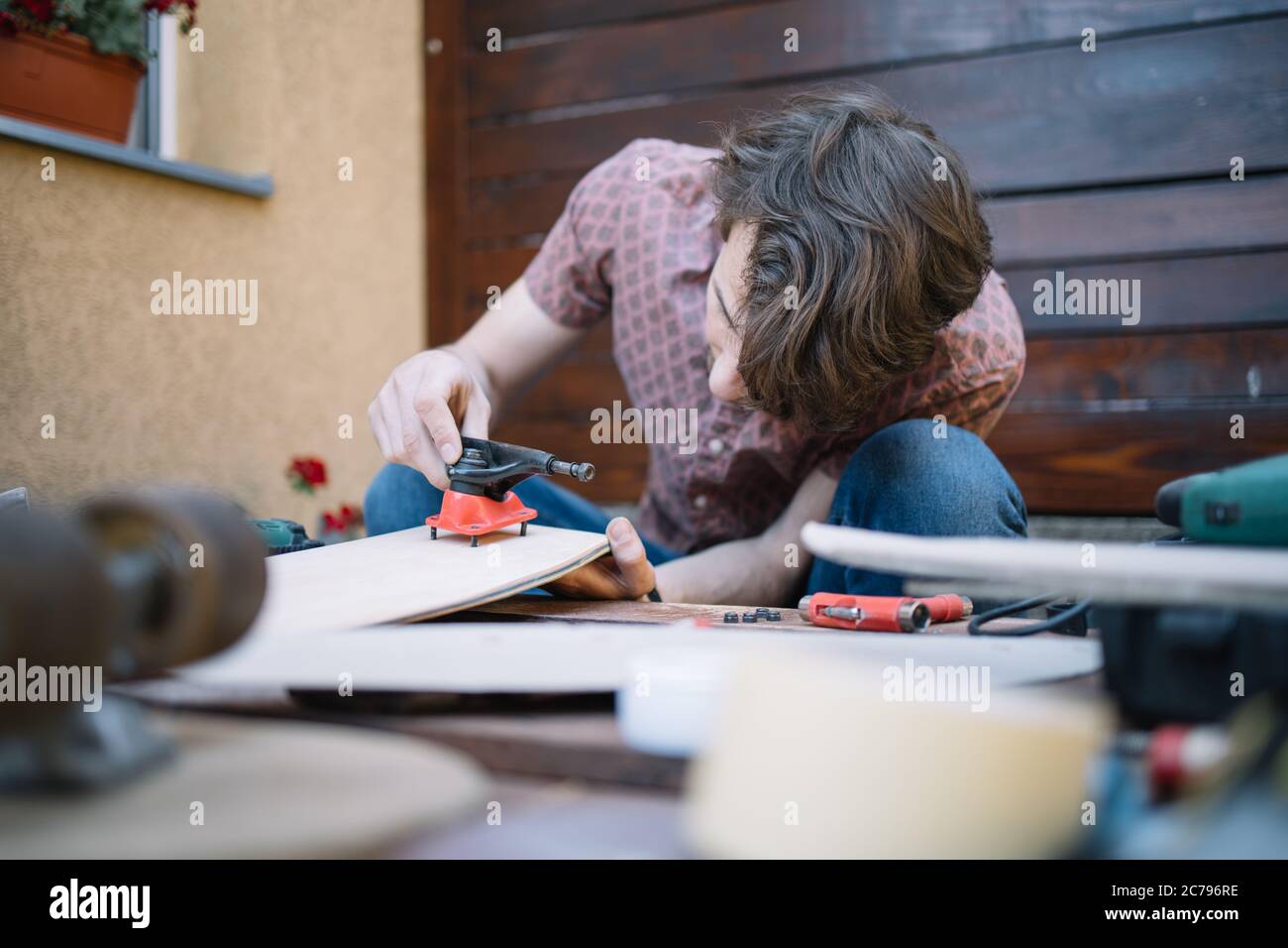 Concentrated man putting skateboard truck on deck Stock Photo Alamy