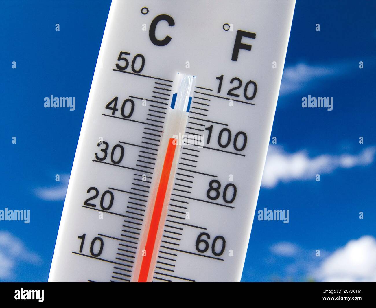 38C HEATWAVE 100F Temperature gauge rising red Concept Thermometer displays hot & sunny 38C centigrade 100F degrees farenheit against a bright blue sky Stock Photo