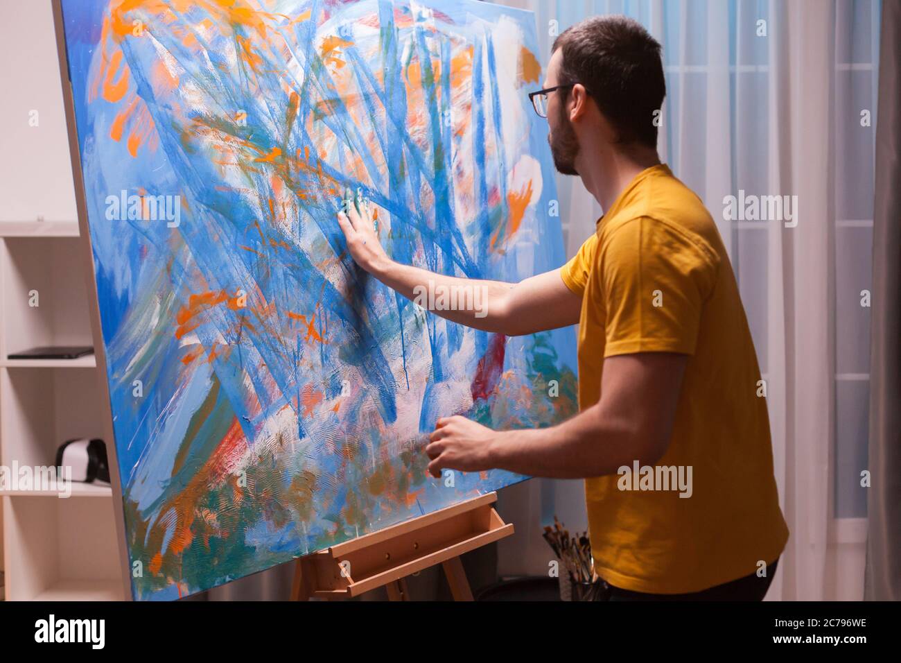 Relaxing painting on canvas with fingertips in art studio. Modern