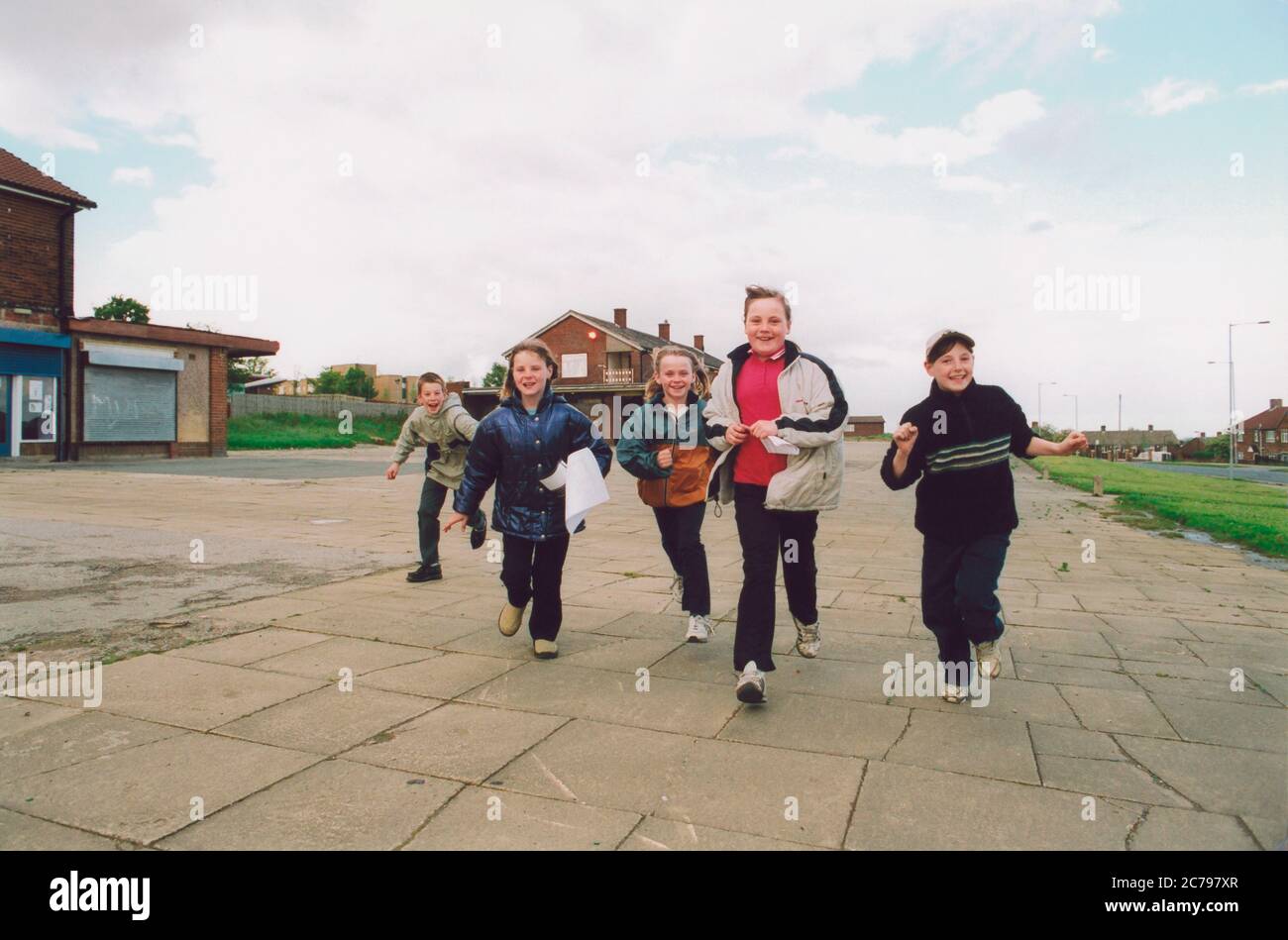Children playing near shops Bradford council housing estate UK Stock Photo