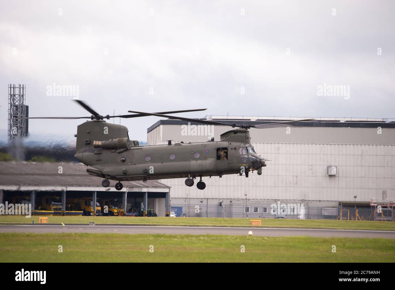 Glasgow, Scotland, UK. 15th July, 2020. Pictured: Royal Air Force Chinook Helicopters seen on the tarmac and taking off from Glasgow International Airport. One of the helicopters had gone ‘technical' with an engine problem and a spare part has been flown in by another Chinook aircraft. A lot of people and plane spotters were seen around the perimeter fence to watch the choppers taking off.  Credit: Colin Fisher/Alamy Live News Stock Photo