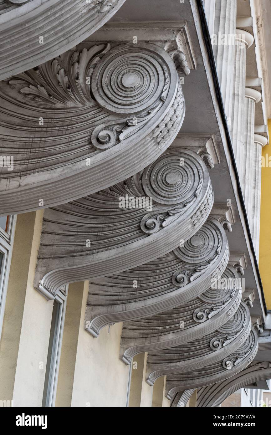 Ornate brackets in waves shape supporting old building balcony, architectural details Stock Photo