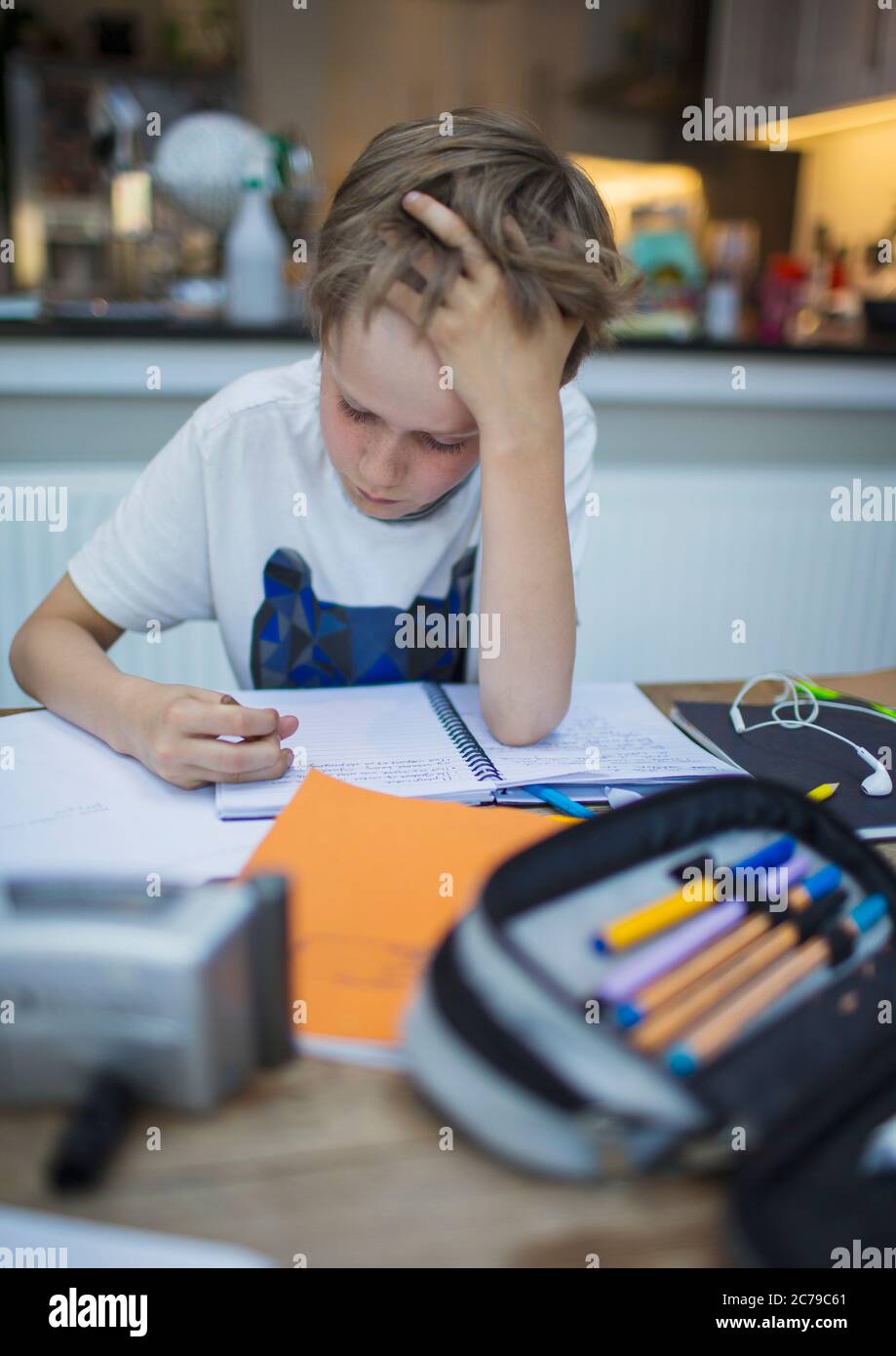 Focused boy home schooling at table Stock Photo