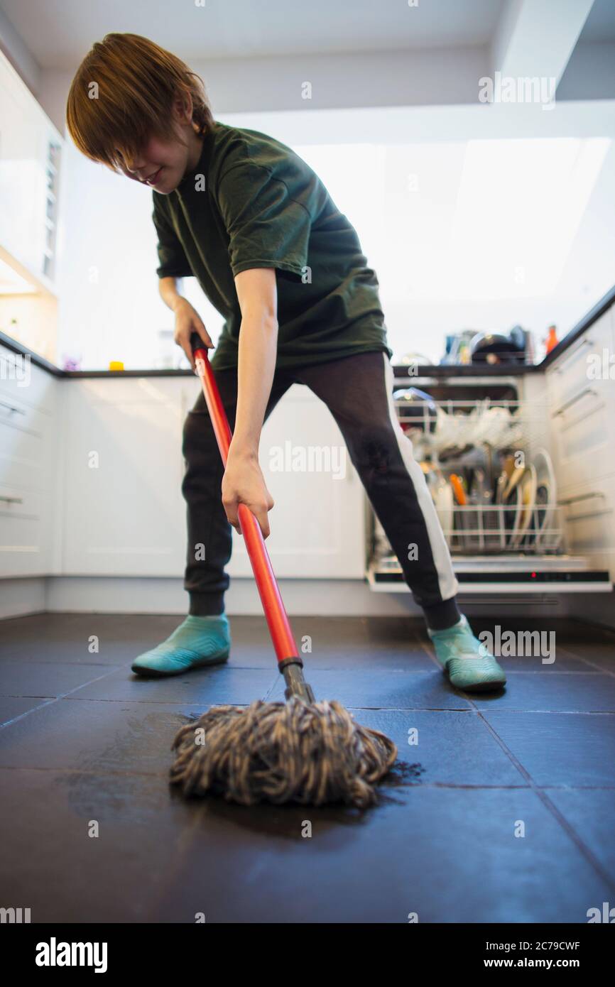 Boy mopping kitchen floor Stock Photo