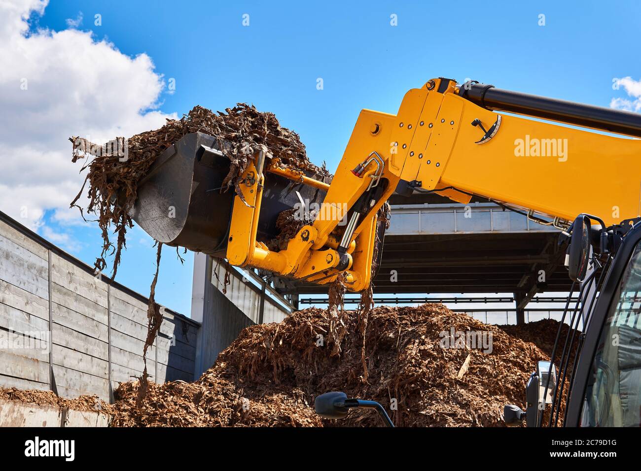 bucket loader moving wood bark in a woodworking industry Stock Photo