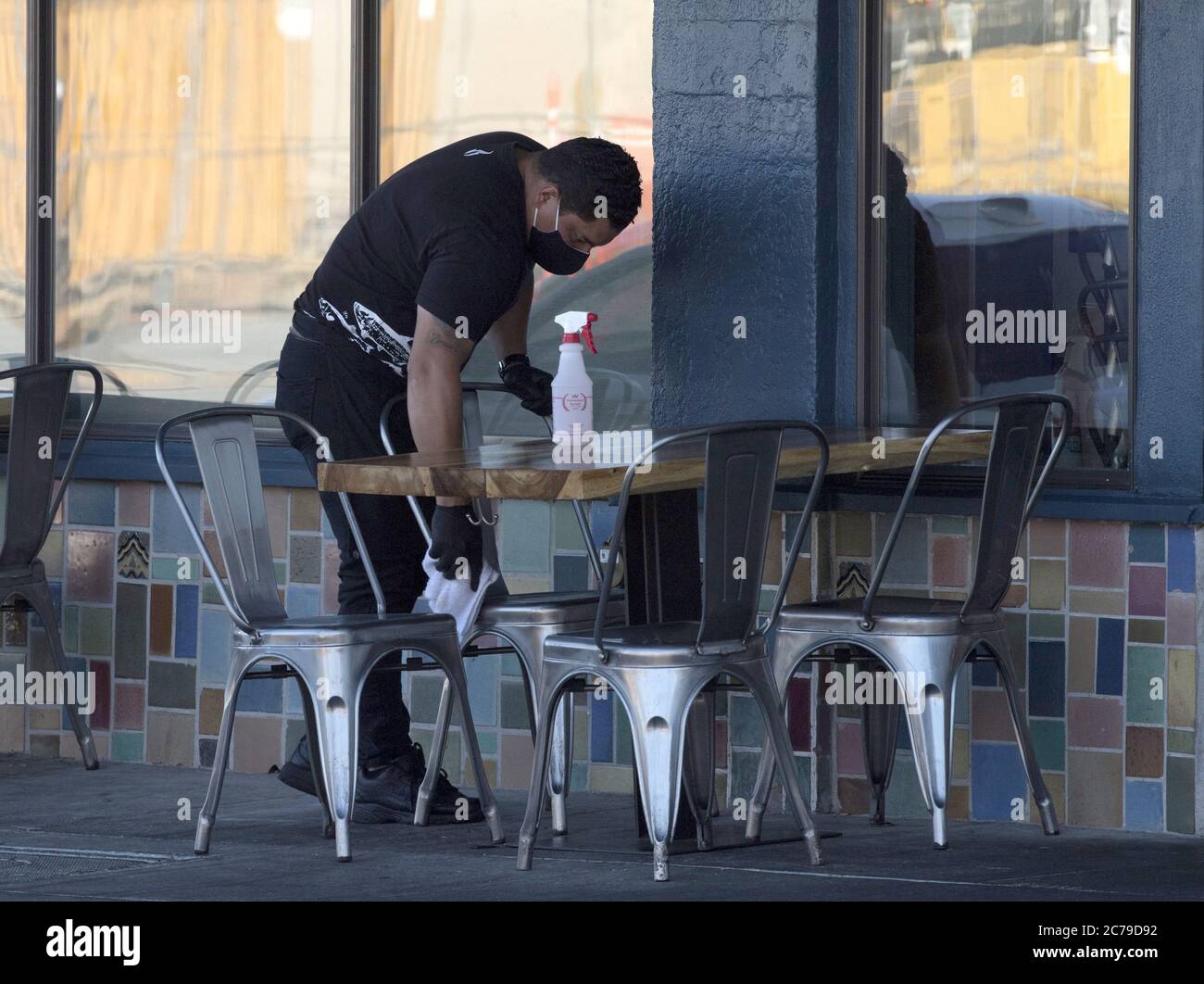 Burlingame, United States. 15th July, 2020. Staff disinfects surfaces betrween customers at sidewalk seating outside Limon Rotisserie in Burlingame, California on Tuesday, July 14, 2020. California's Governor Gavin Newsom has ordered a rollback in openings and an end to inside dining amid a spike in COVID-19 cases across the state. Photo by Terry Schmitt/UPI Credit: UPI/Alamy Live News Stock Photo