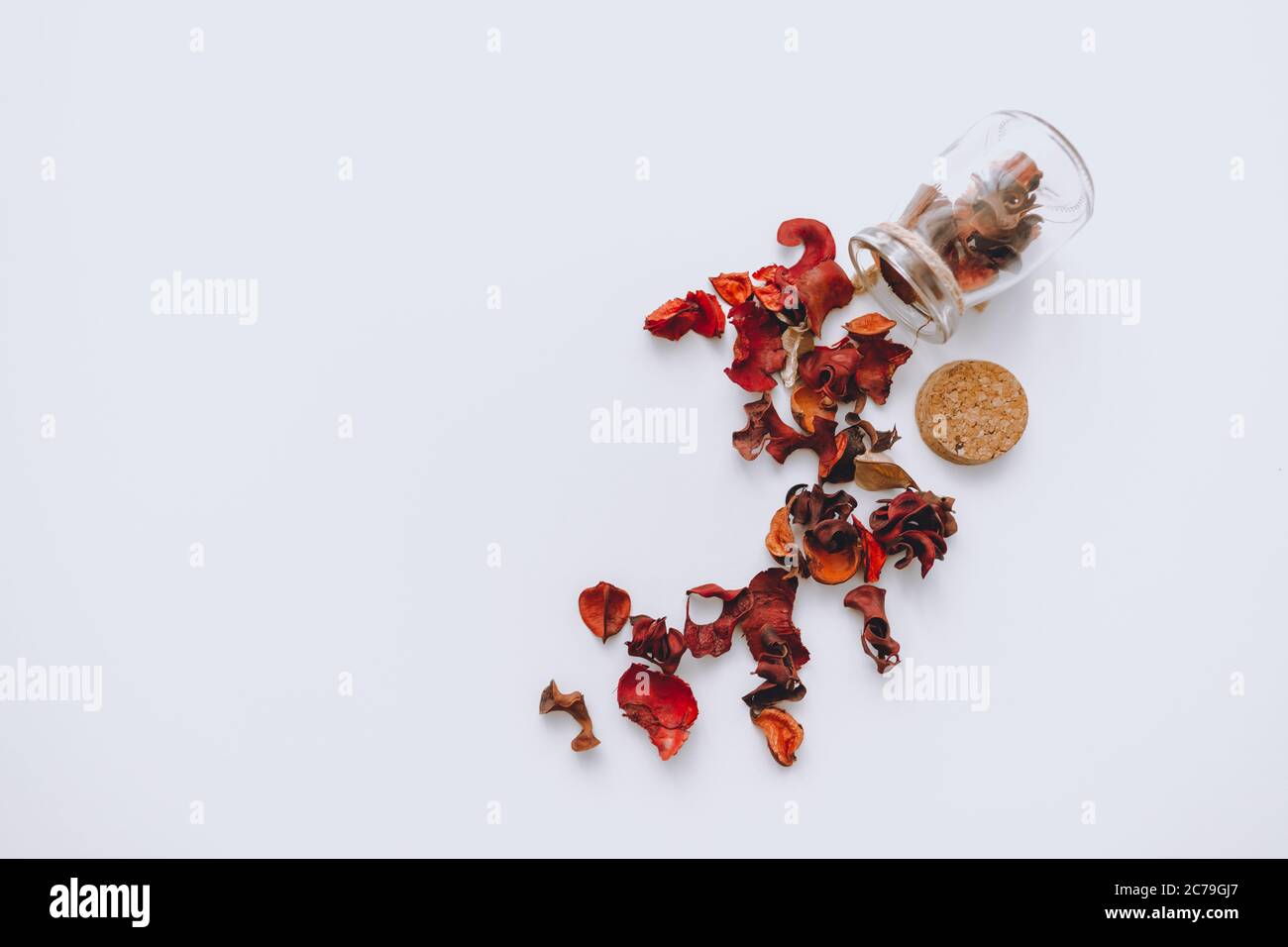 Glass jar with red scattered dried petals isolated on a white background Stock Photo
