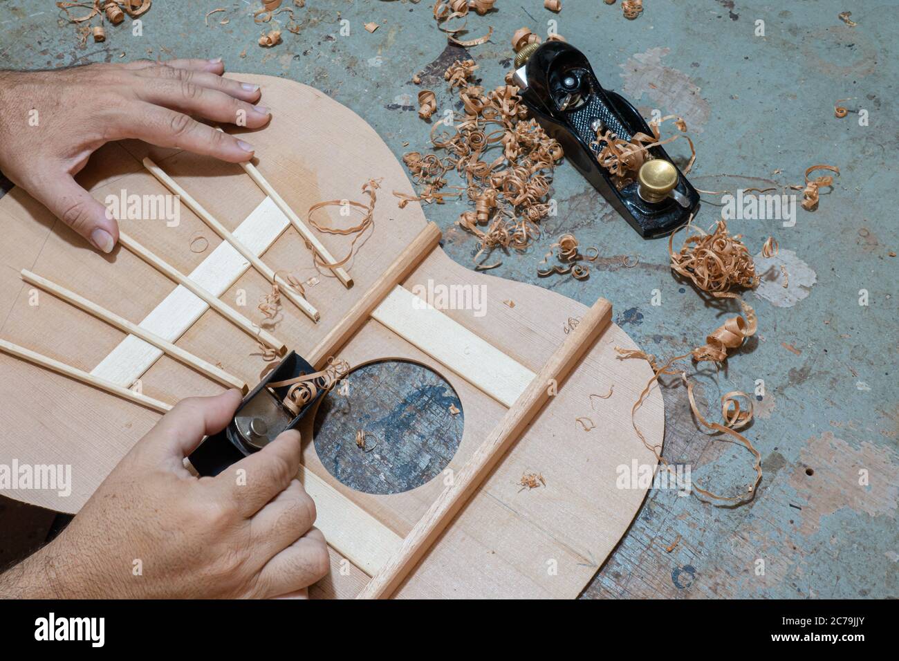 Luthier workbench with tools and a top of an acoustic guitar under