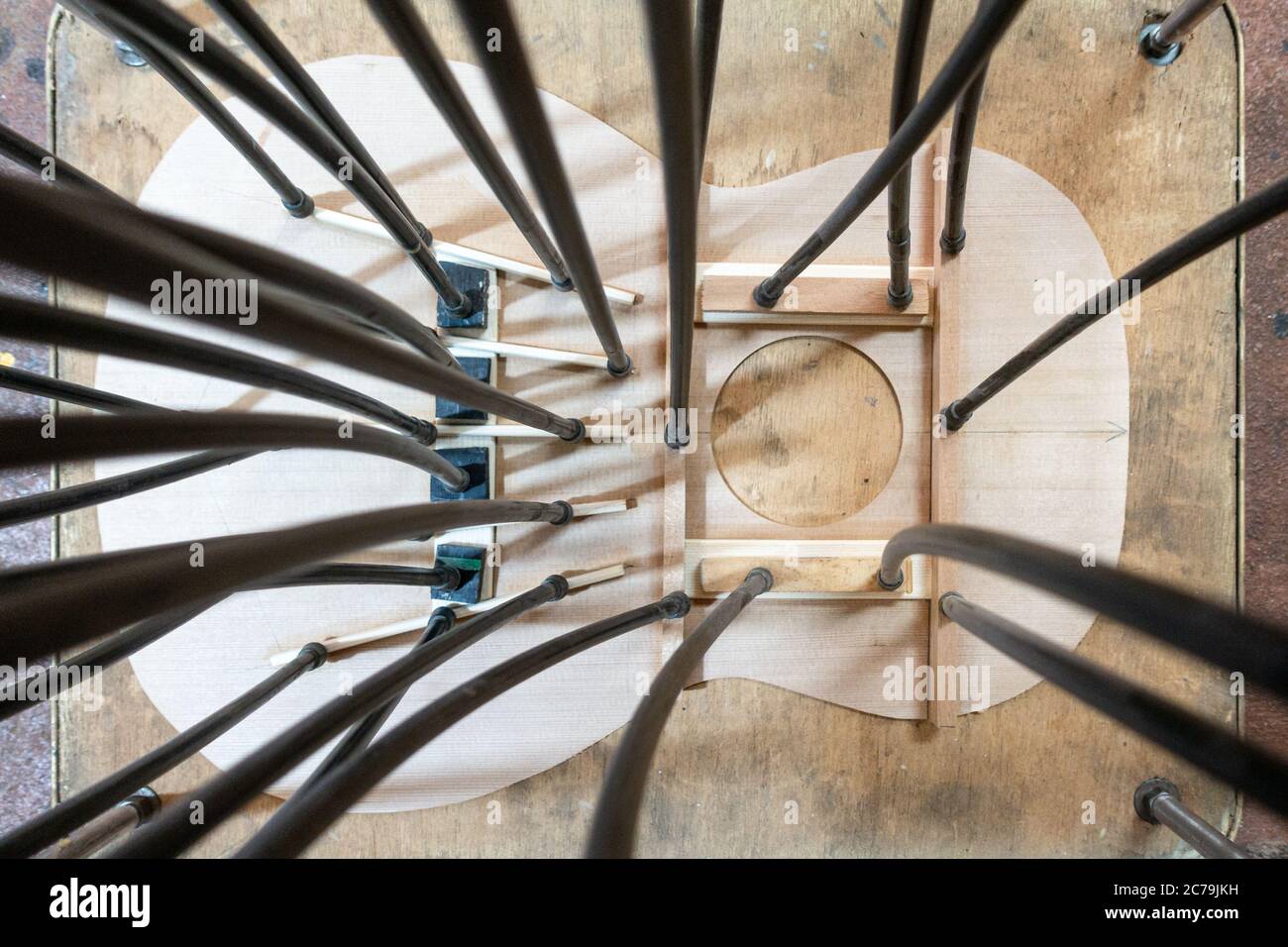 Luthier workbench with tools and a top of an acoustic guitar under