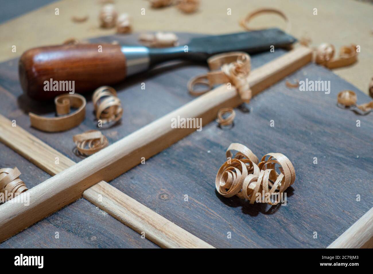 Luthier workbench with tools and back piece of an acoustic guitar under
