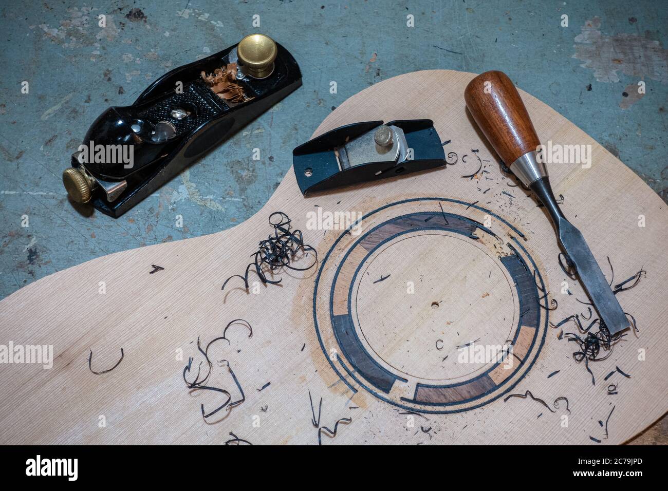 Luthier workbench with tools and a top of an acoustic guitar under