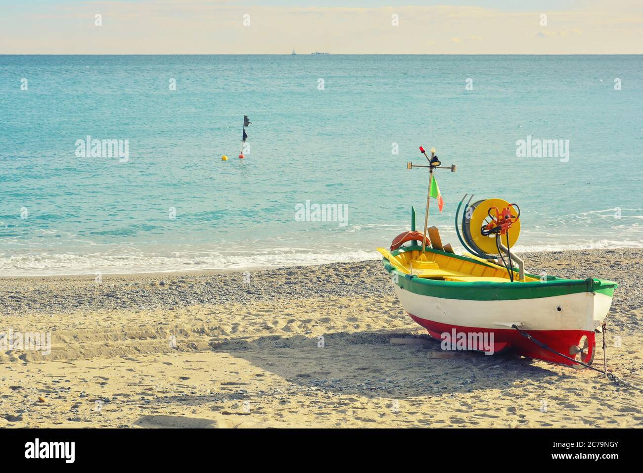 Noli, Savona, Liguria, Italy. A boat aground on the beach of Noli, a seaside village in the province of Savona, on a clear winter day. Stock Photo