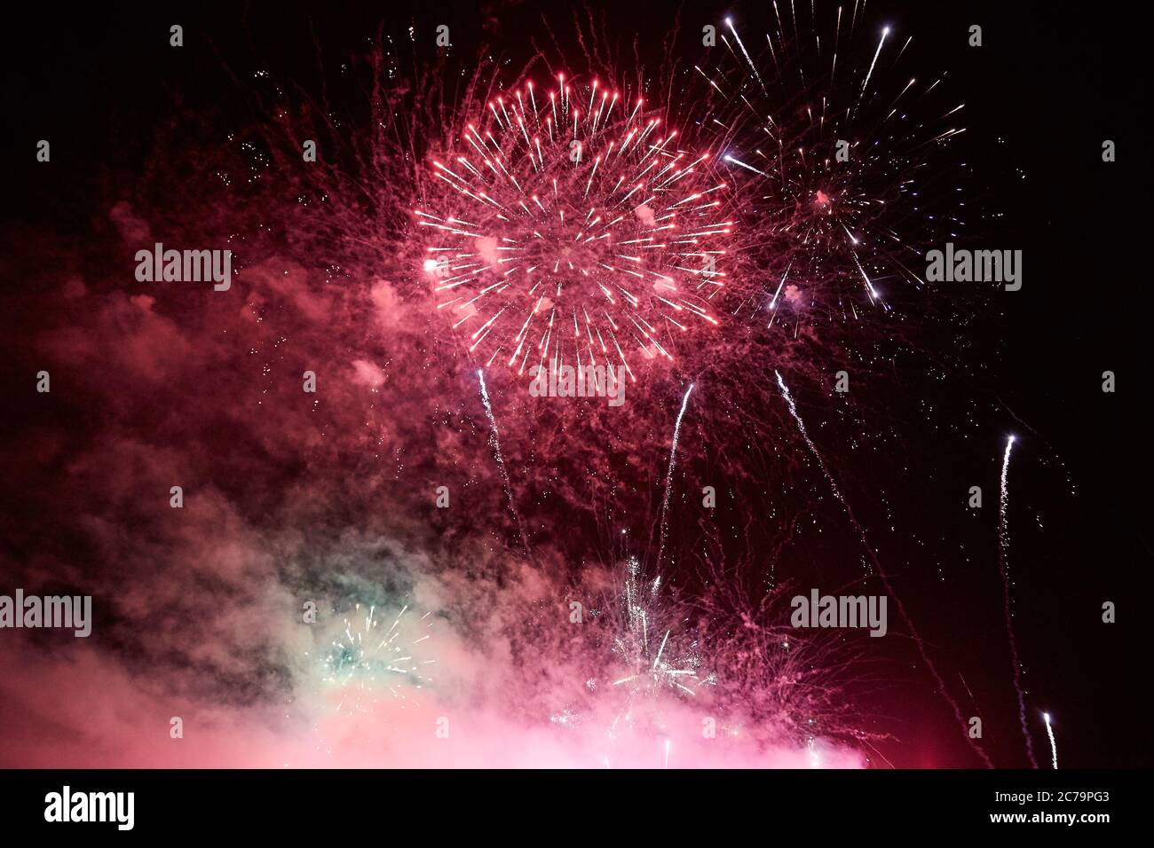 Fireworks for the holiday from different colorful explosions in the night sky Stock Photo
