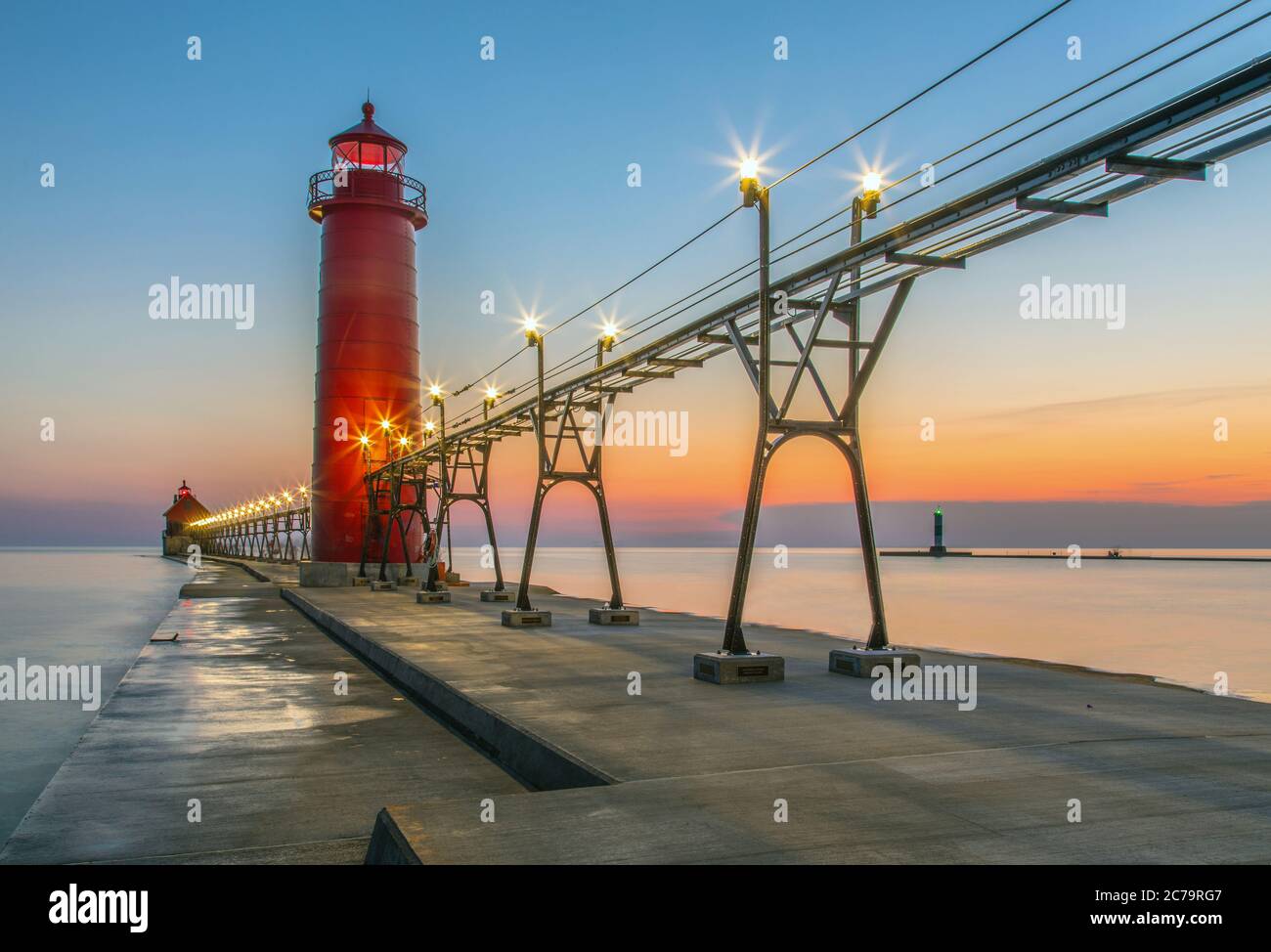 Grand Haven South Pier Lighthouse at sunset, with views of the Grand River and Lake Michigan; Grand Haven, Michigan Stock Photo