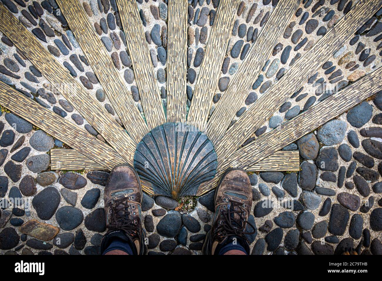 The way of saint James or compostelle . well worn Walking shoes with scallop shell.Nasbinals Lozere,France. Stock Photo