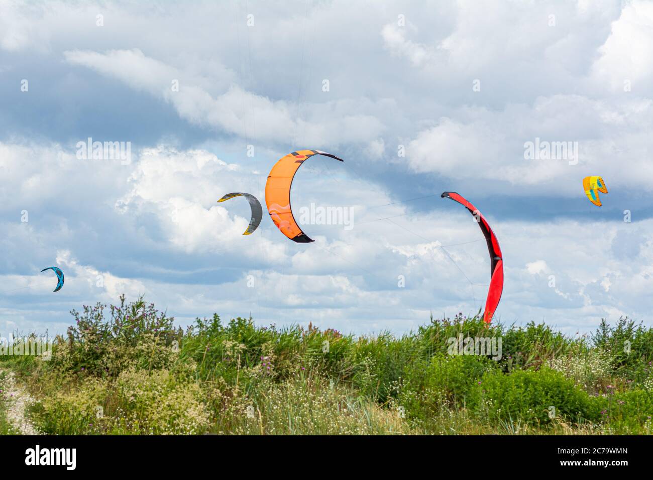Malmo, Sweden - July 12, 2020: On a windy day many people take the opportunity to do watersports. Kitesurfers gather near Lomma beach to practice their kite surfing skills Stock Photo