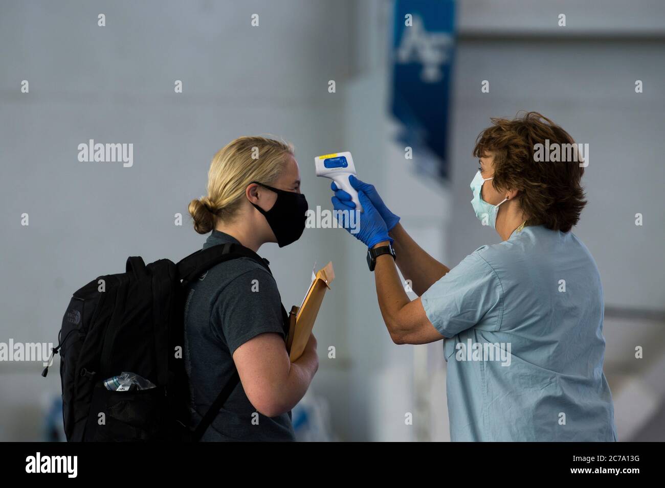 A U.S. Air Force medic checks the temperature of academy cadets from the class of 2024 on arrival, as they become the first cadet class under the COVID-19 pandemic at the Air Force Academy June 25, 2020 in Colorado Springs, Colorado. Stock Photo