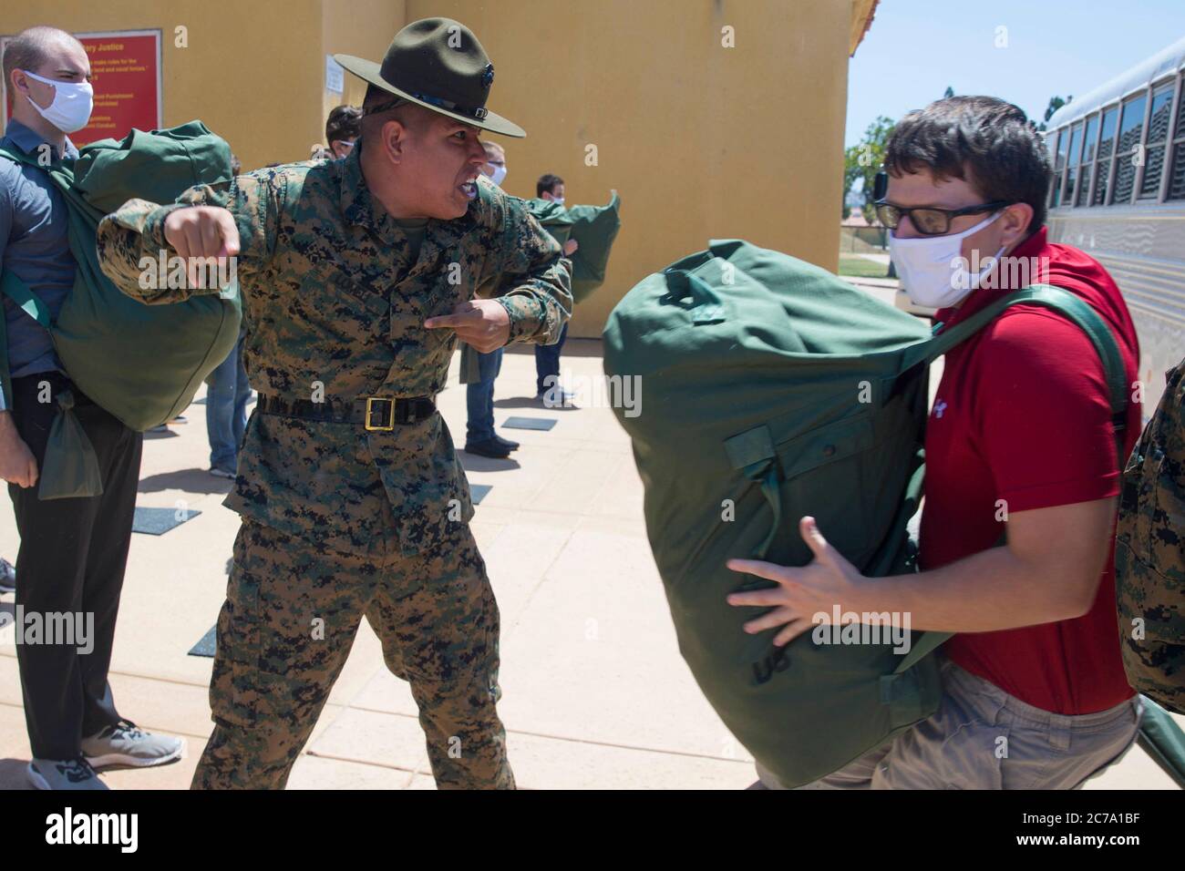 U.S. Marine SSgt. Ricardo Lomeli, a senior drill instructor, welcomes new recruits with Charlie Company, 1st Recruit Training Battalion, during receiving at Marine Corps Recruit Depot July 7, 2020 in San Diego, California. Stock Photo