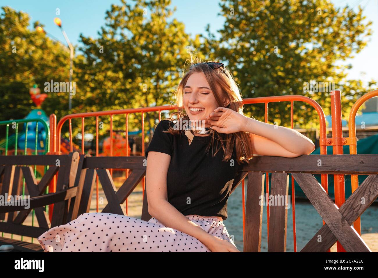 Summer vacation. A beautiful young woman is sitting on a Park bench ...