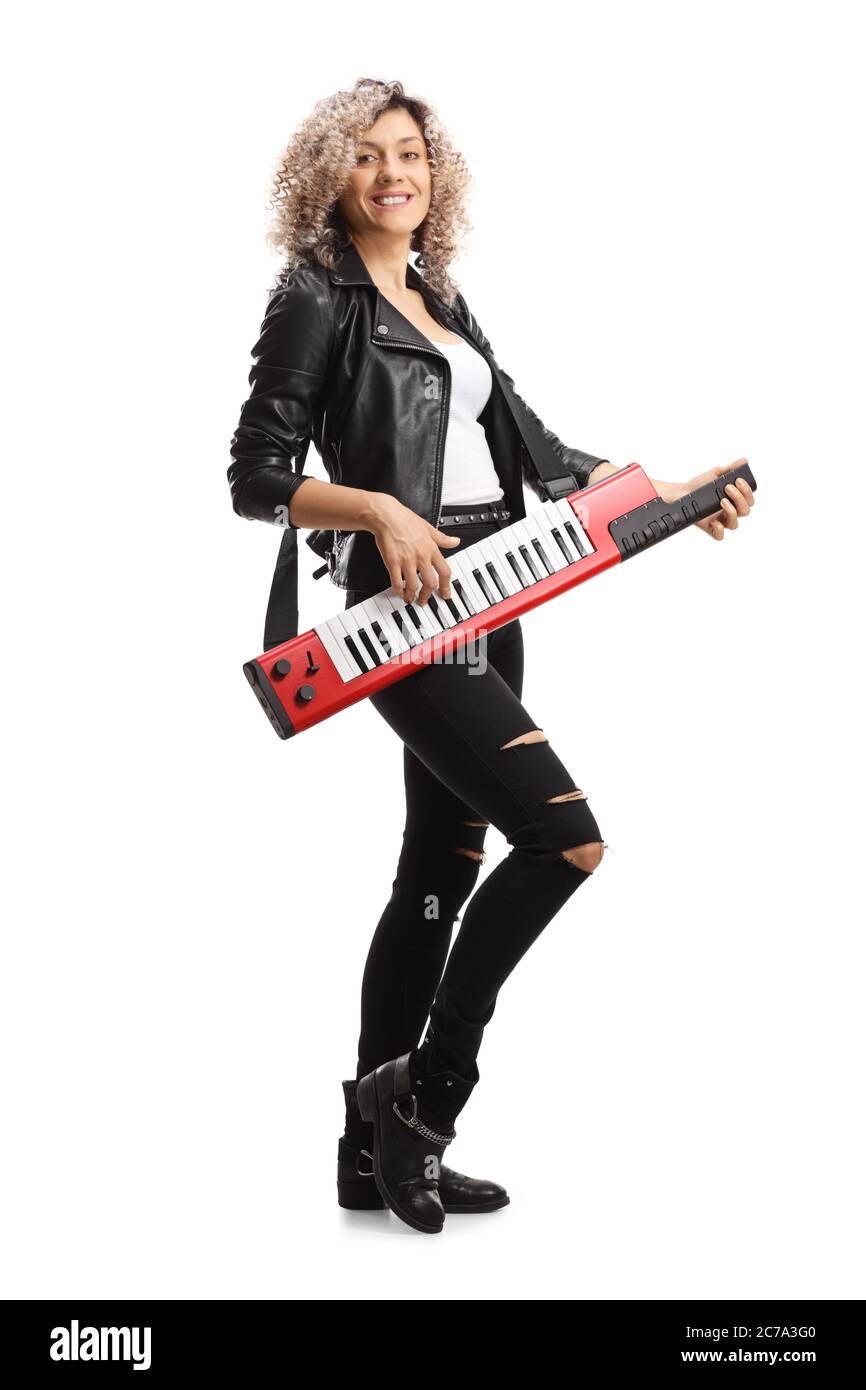 Full length portrait of a woman in leather clothing playing a keytar synthesizer isolated on white background Stock Photo