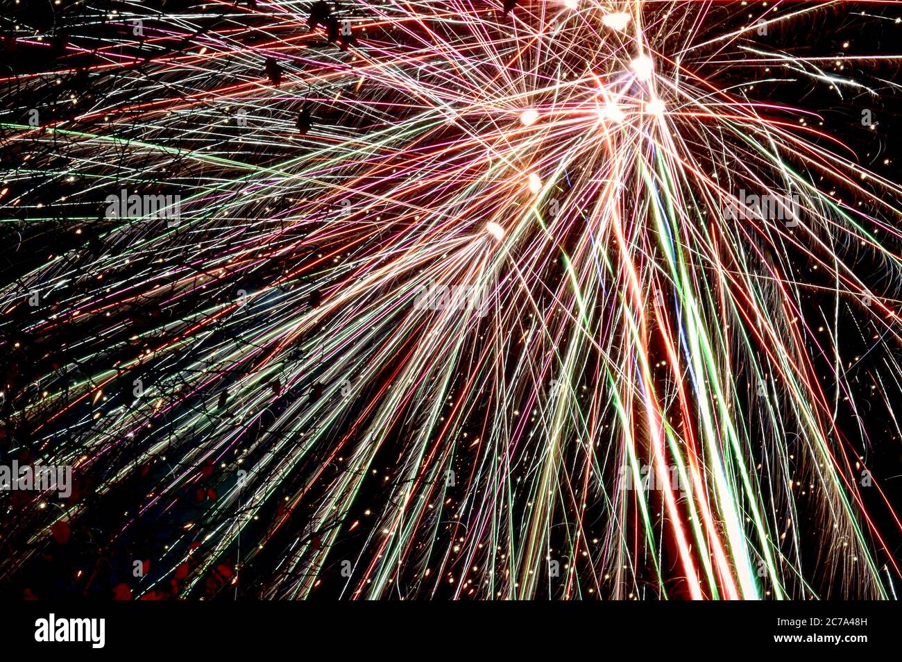 Colourful fireworks exploding in night sky long exposure light trail Stock Photo