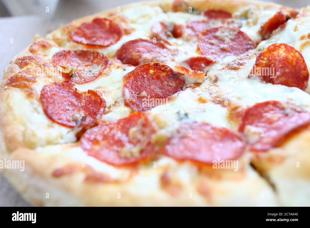 Fresh baked pizza with crusty cheese and hot tasty pepperoni ready to