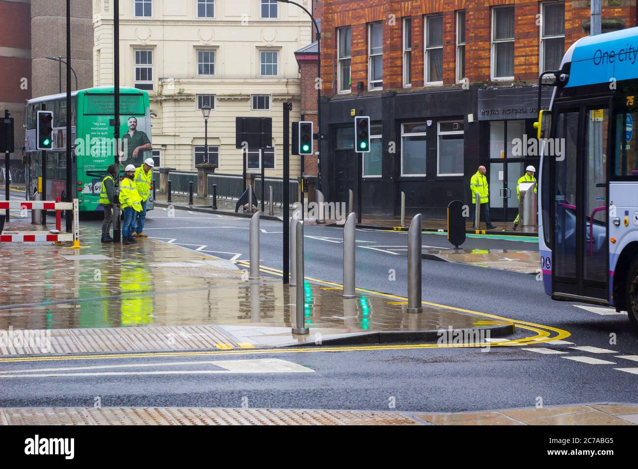 8 July 2020 Workmen wearing hi visibility clothing and hard hats on Bridge Street in empty downtown Sheffield England during the Covid 19 crisis. Stock Photo