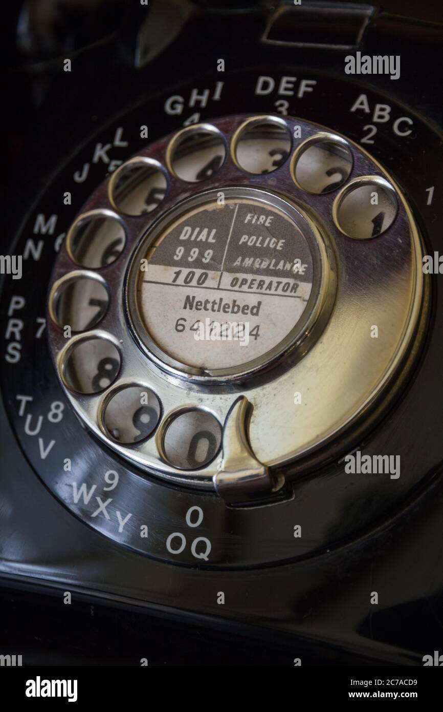 Old vintage British spring loaded metal telephone rotating numerical dial on black GPO bakelite phone with Nettlebed 641224 number at Oxfordshire,UK Stock Photo
