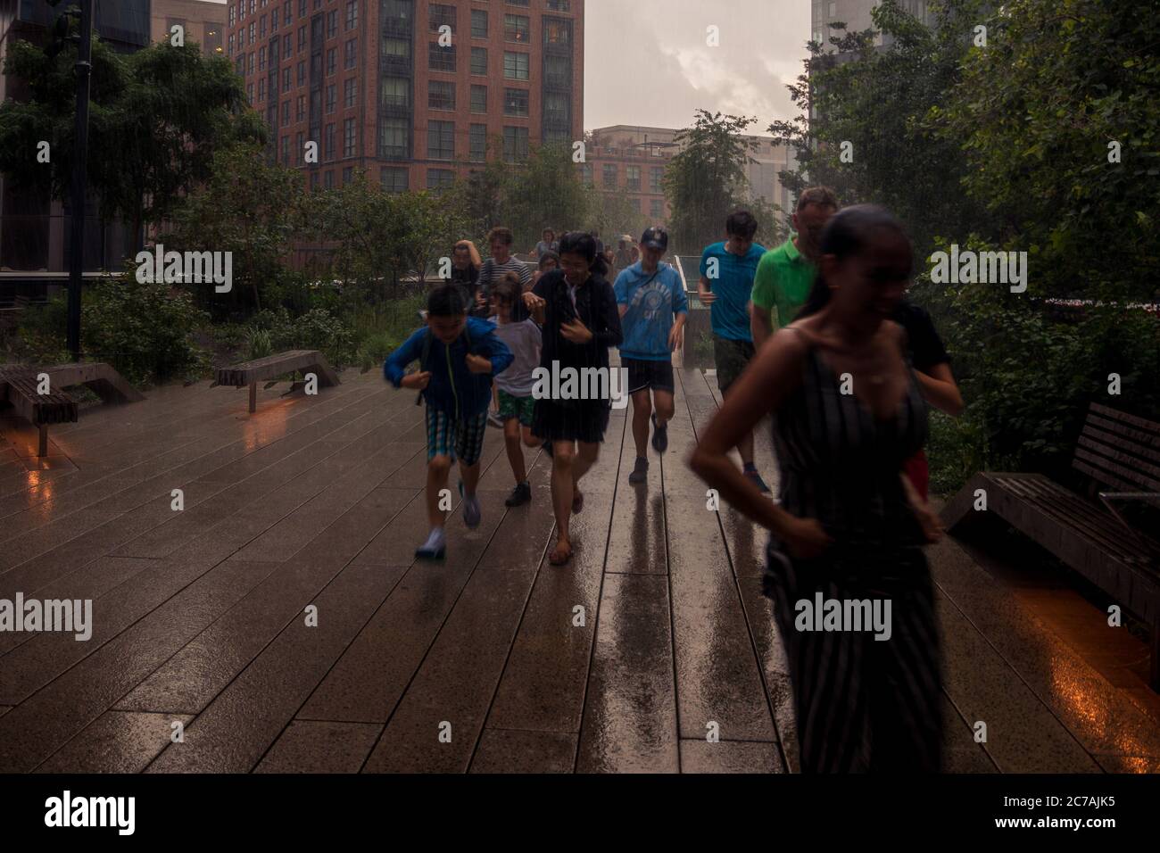 New York, NY, USA - July 22, 2019: Pedestrians Run For Shelter From A Sudden Rainstorm Stock Photo