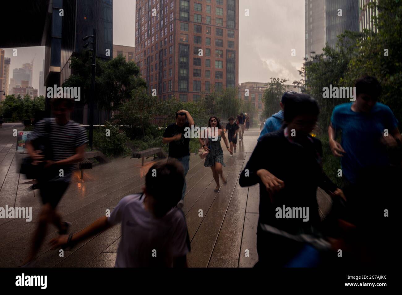 New York, NY, USA - July 22, 2019: Pedestrians Run For Shelter From A Sudden Rainstorm Stock Photo