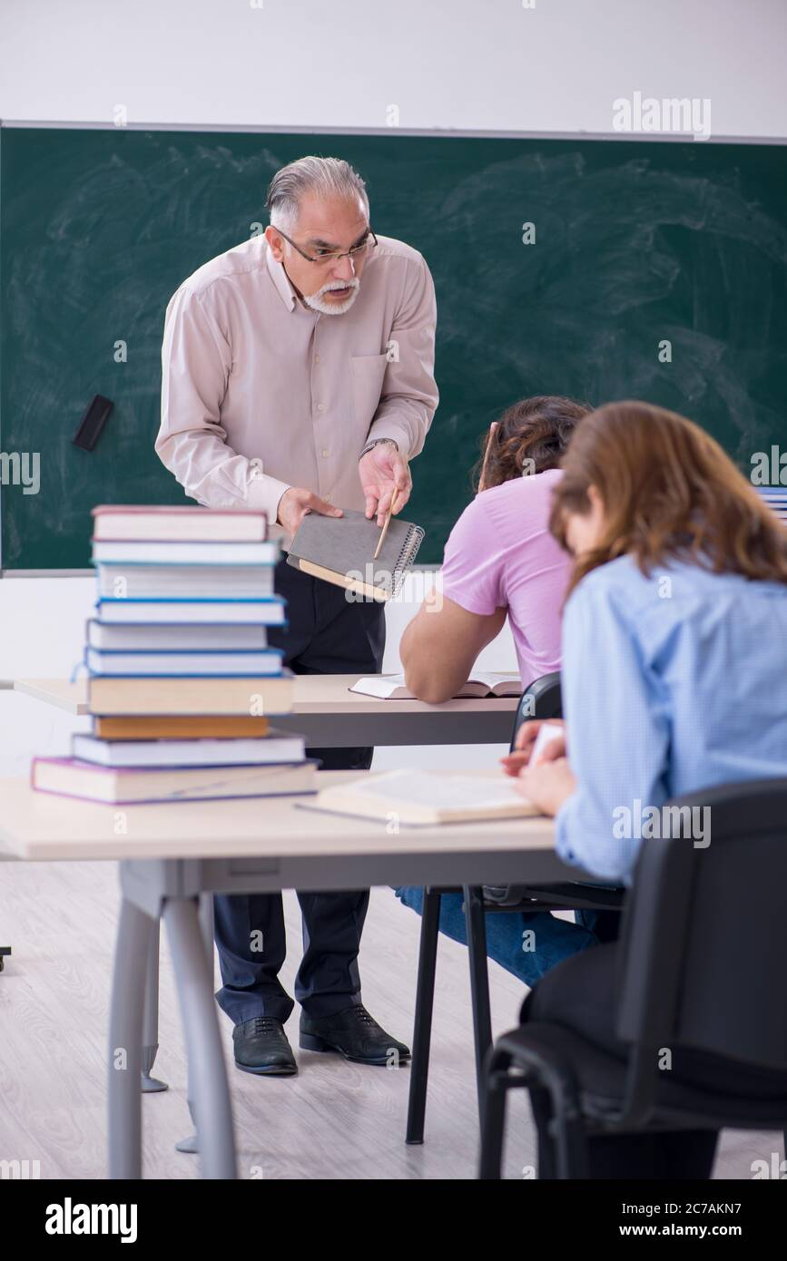 Old teacher and two students in the classroom Stock Photo - Alamy