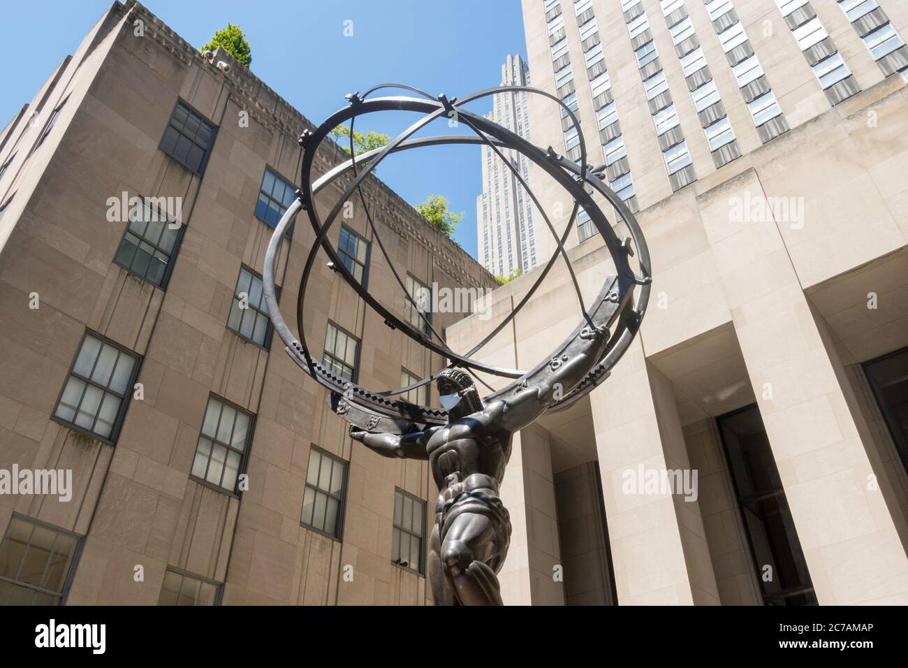 Ancient Greek Titan Atlas Holding the Heavens Bronze Armillary Sphere Sculpture in Rockefeller Center wearing a face mask due to COVID-19, NYC, USA Stock Photo