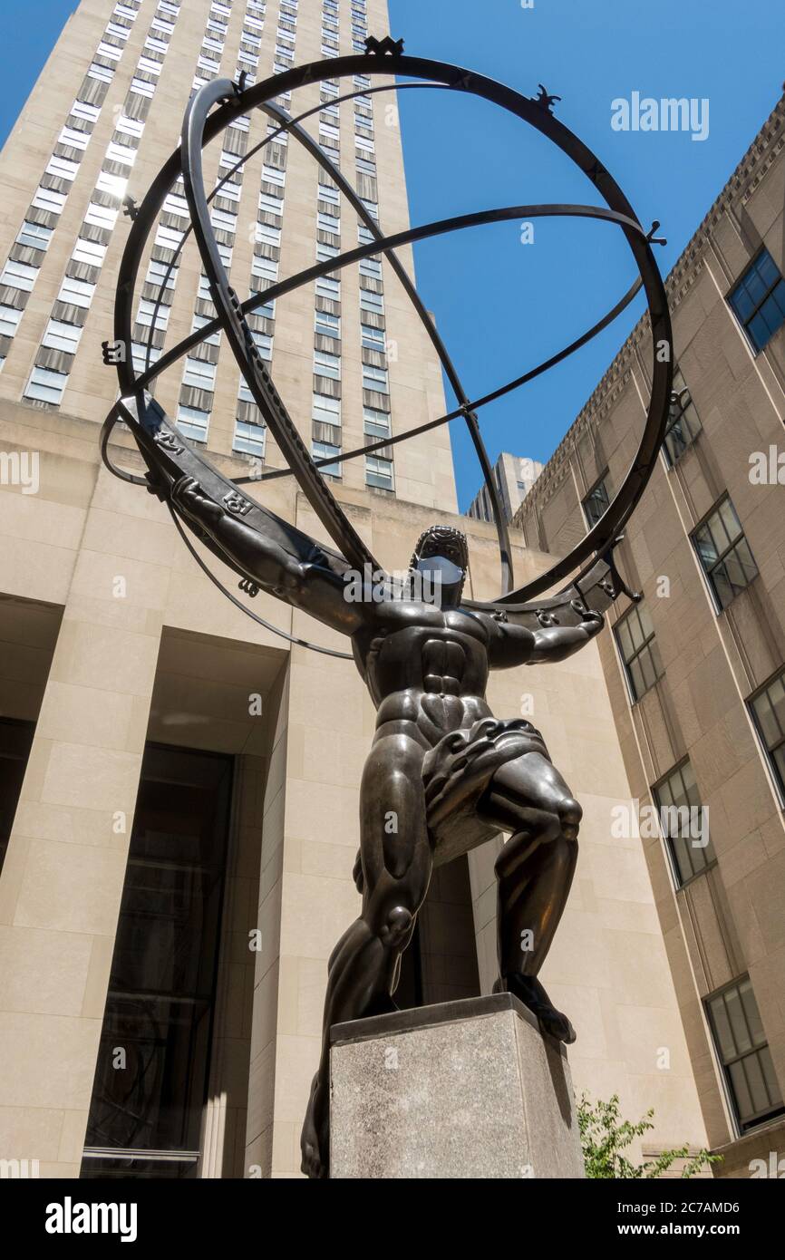 Ancient Greek Titan Atlas Holding the Heavens Bronze Armillary Sphere Sculpture in Rockefeller Center wearing a face mask due to COVID-19, NYC, USA Stock Photo