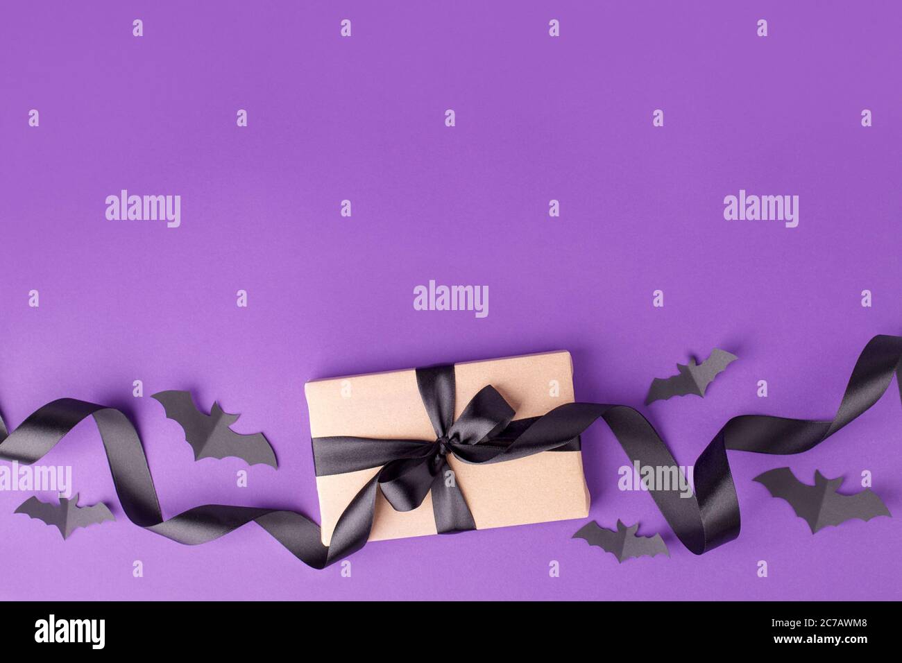 Halloween background with gifts boxes, satin bow ribbon and decorative papercraft bats on traditional purple background, seasonal holiday, sale, black Stock Photo