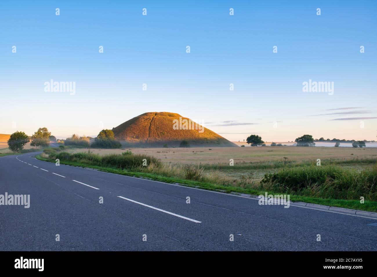 Silbury Hill and mist in the summer at sunrise. Avebury, Wiltshire, England Stock Photo