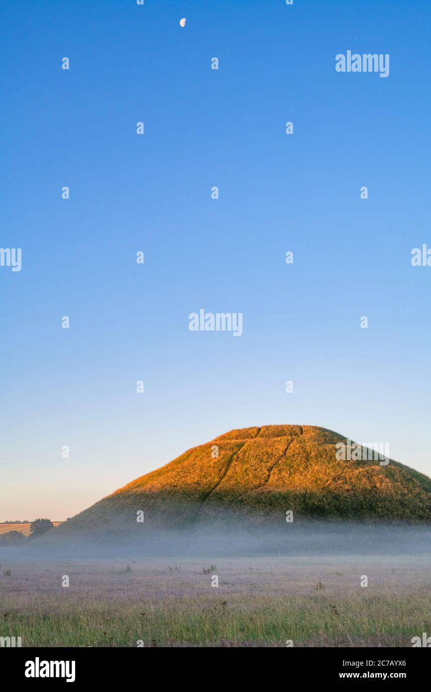 Silbury Hill and mist in the summer at sunrise. Avebury, Wiltshire, England Stock Photo