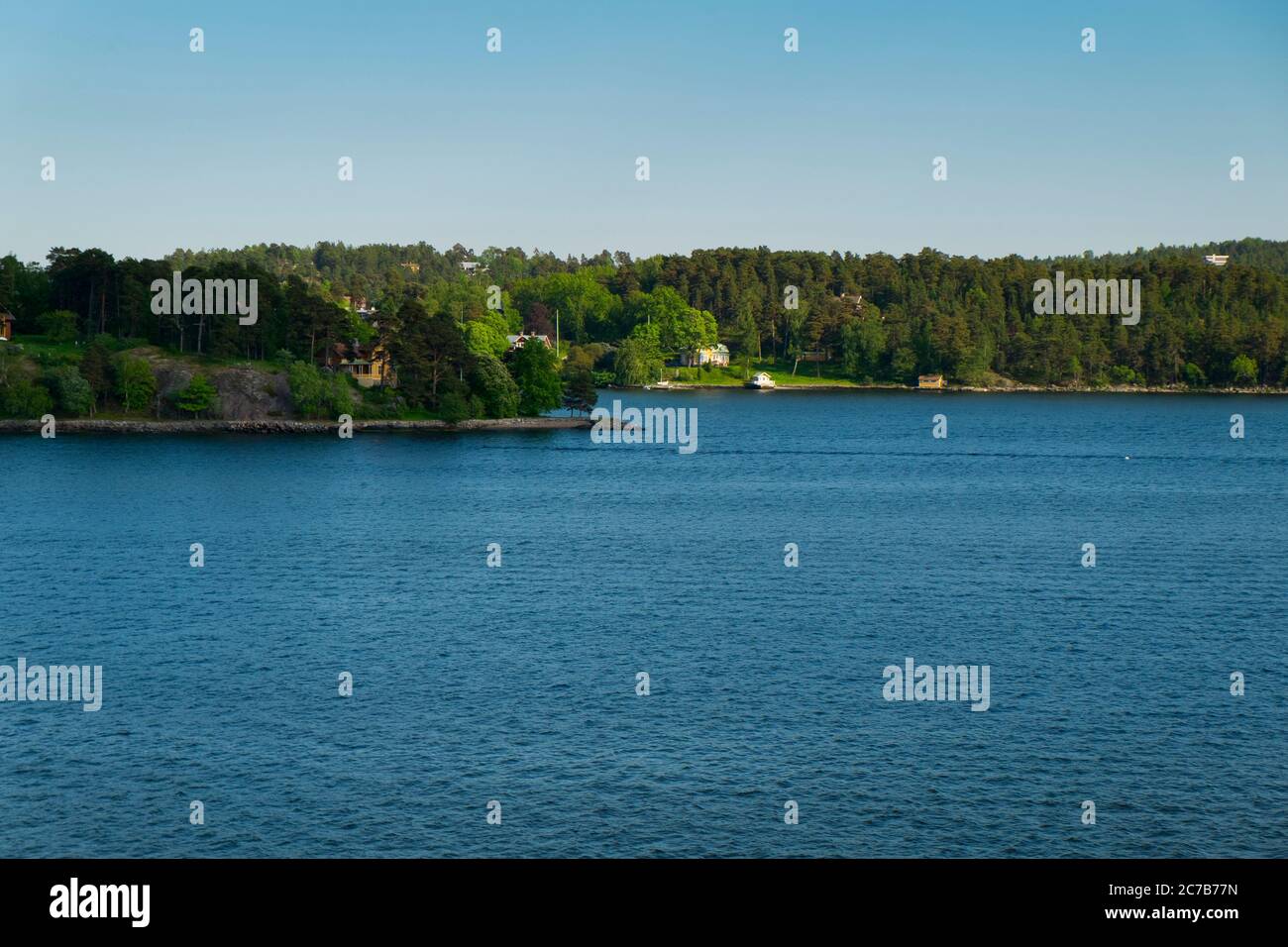 The view of some of the coastline housing during late afternoon light. Cruising Lake Mälaren near Stockholm, Sweden. Stock Photo