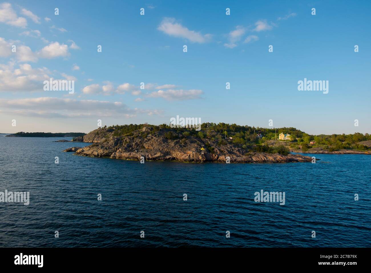 The rocky coastline during late afternoon golden sunset. Cruising Lake Mälaren near Stockholm, Sweden. Stock Photo