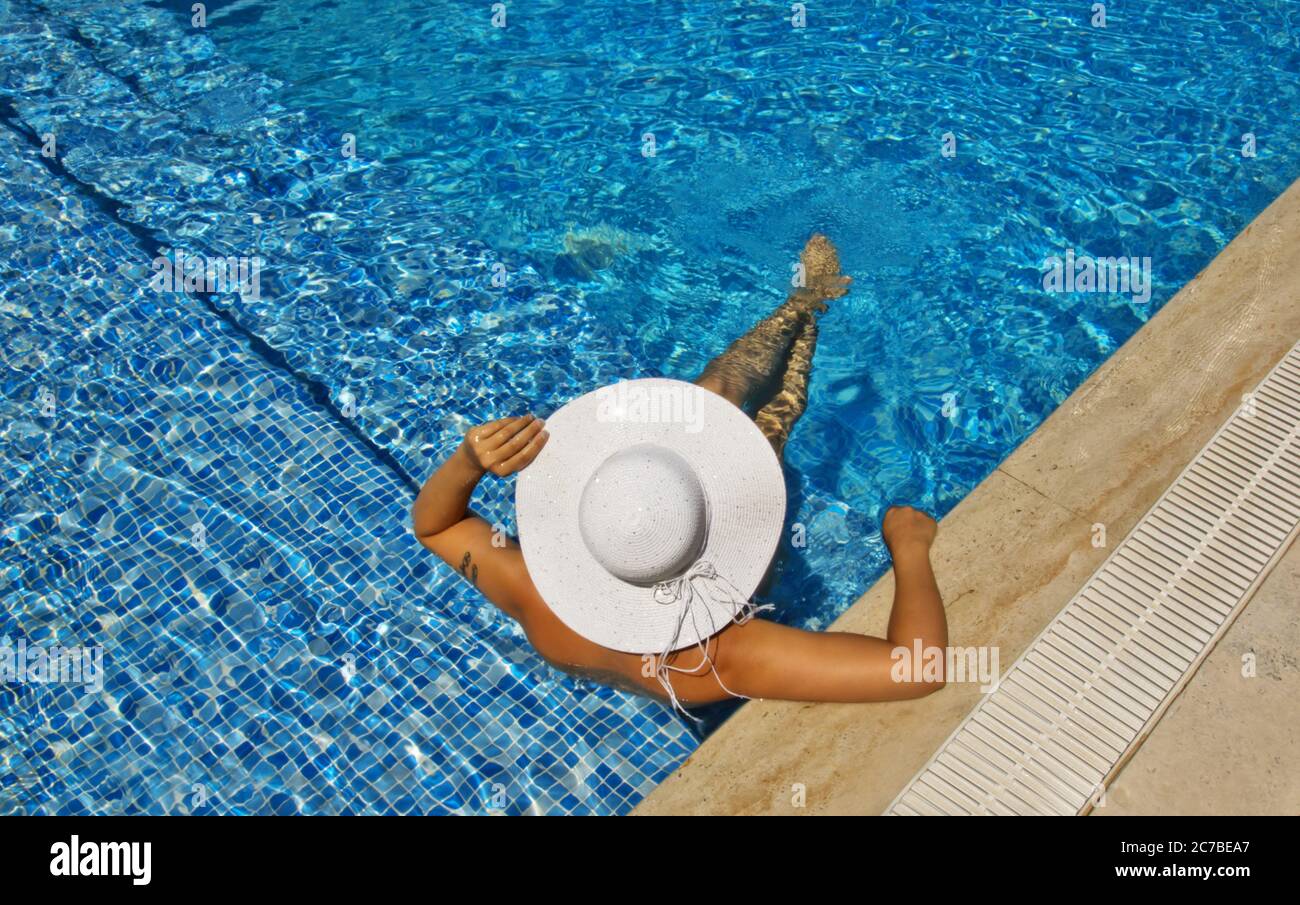 young woman in a white hat relaxing in the pool Stock Photo - Alamy