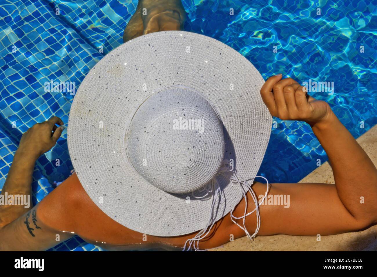 young woman in a white hat relaxing in the pool Stock Photo - Alamy