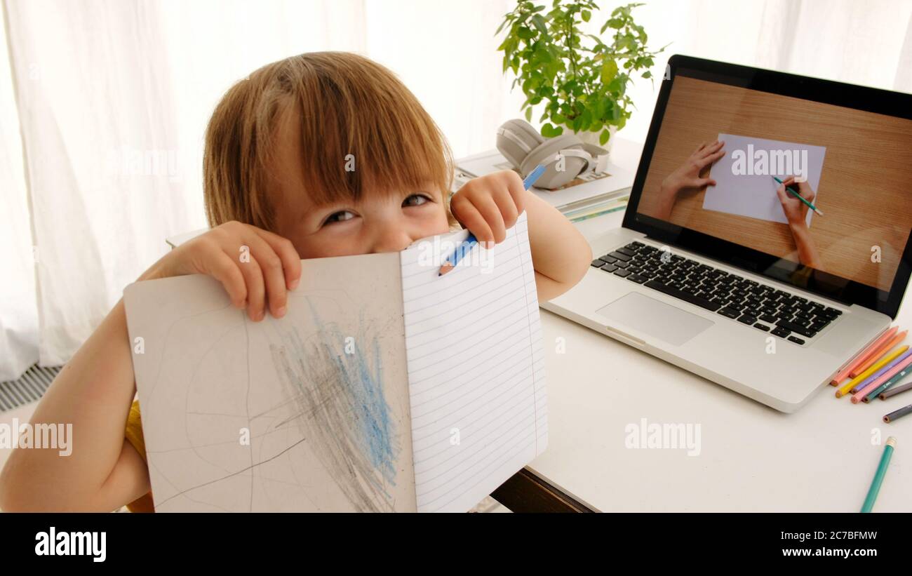 Funny kid learning to draw online Stock Photo