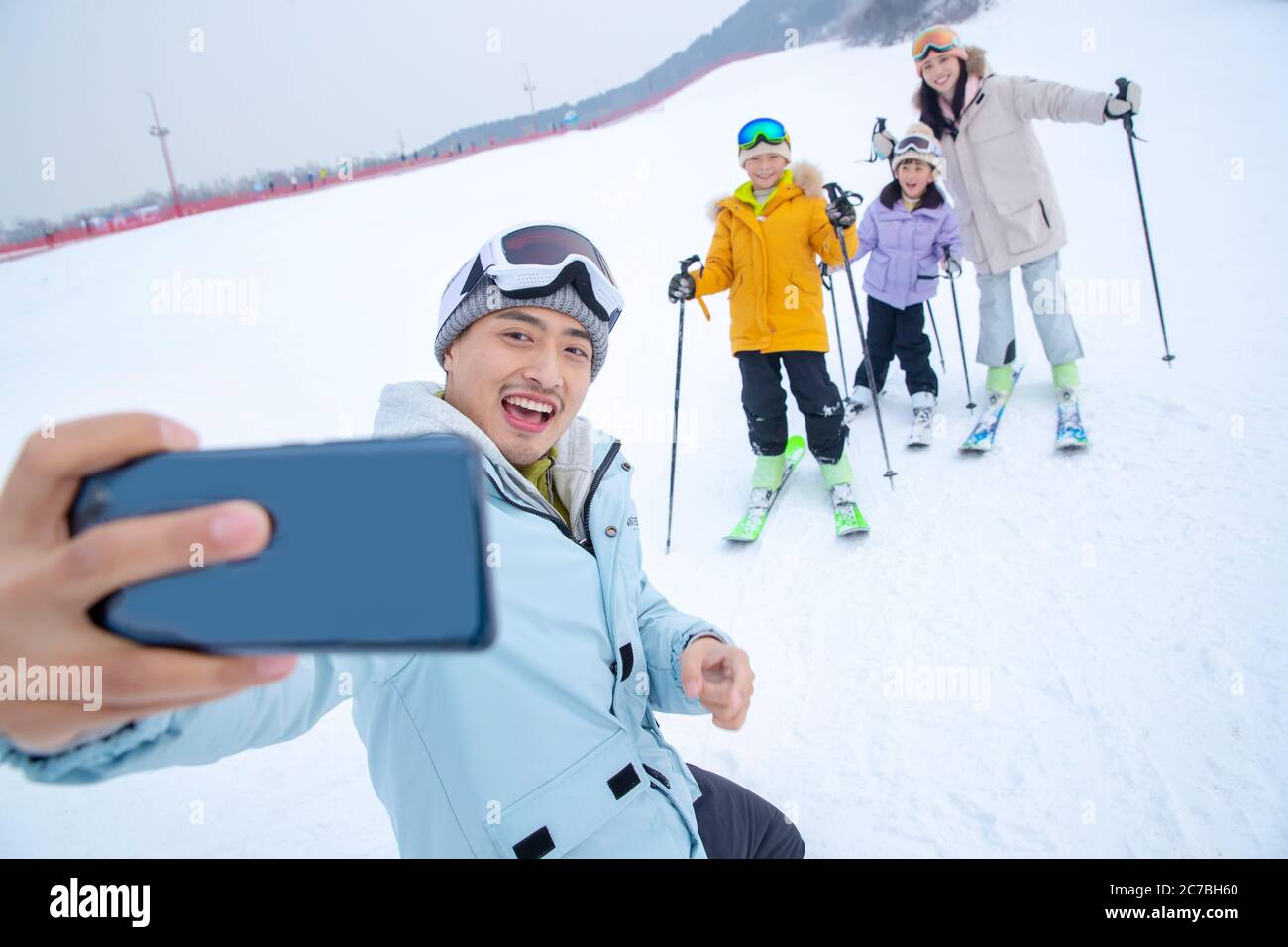 Skiing field using a mobile phone take a family of four Stock Photo Alamy