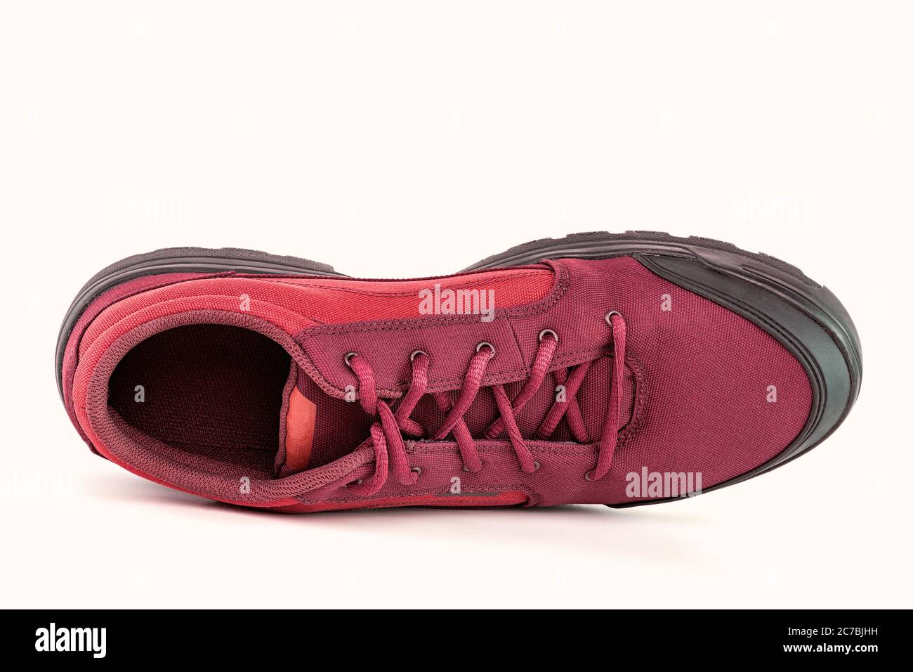 one right cheap red fabric hiking or hunting shoe isolated on white background Stock Photo