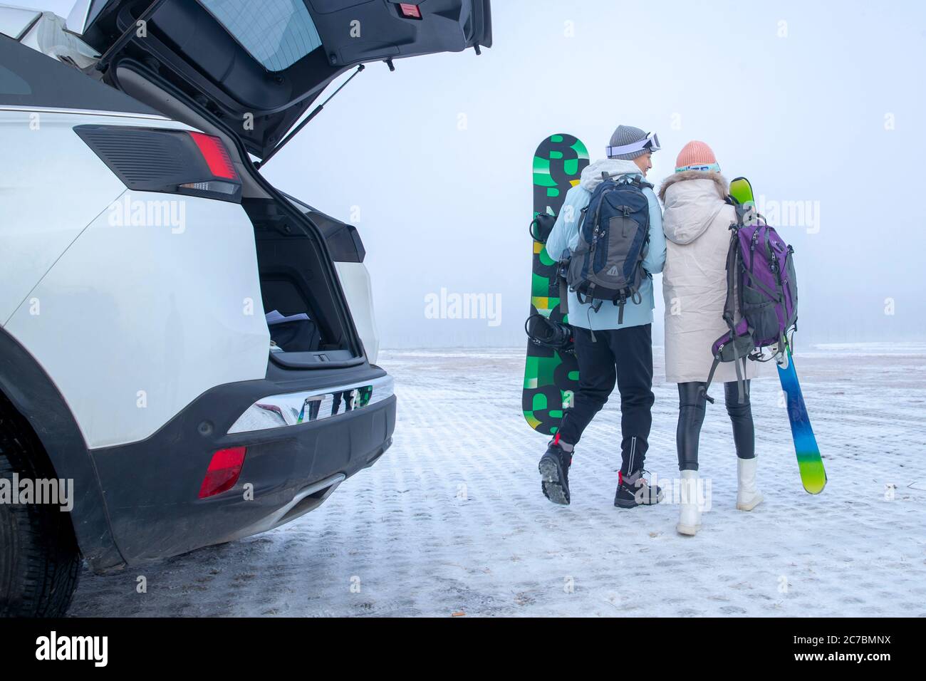 The back of young couples with skis Stock Photo