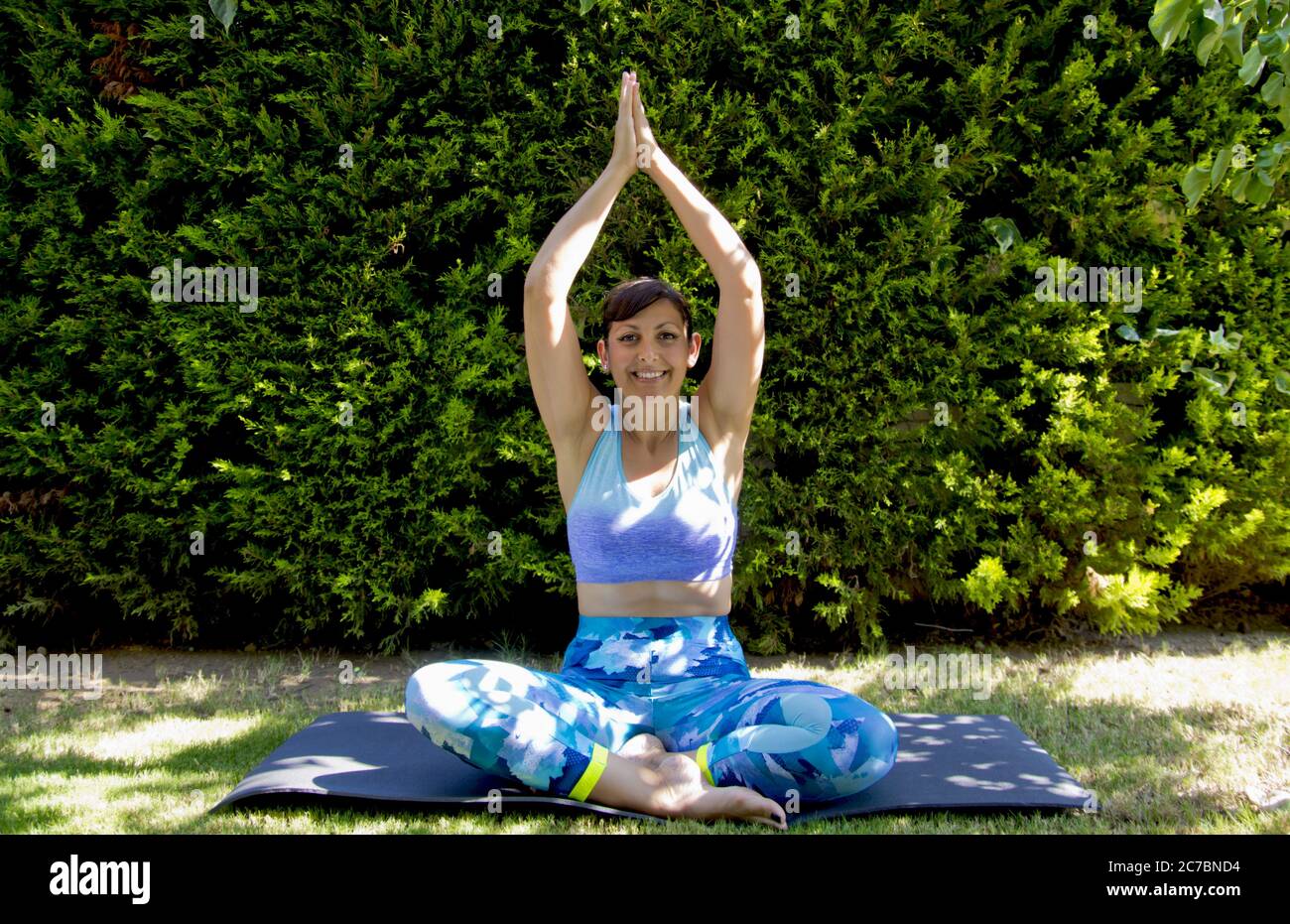 Young woman doing yoga in the garden Stock Photo