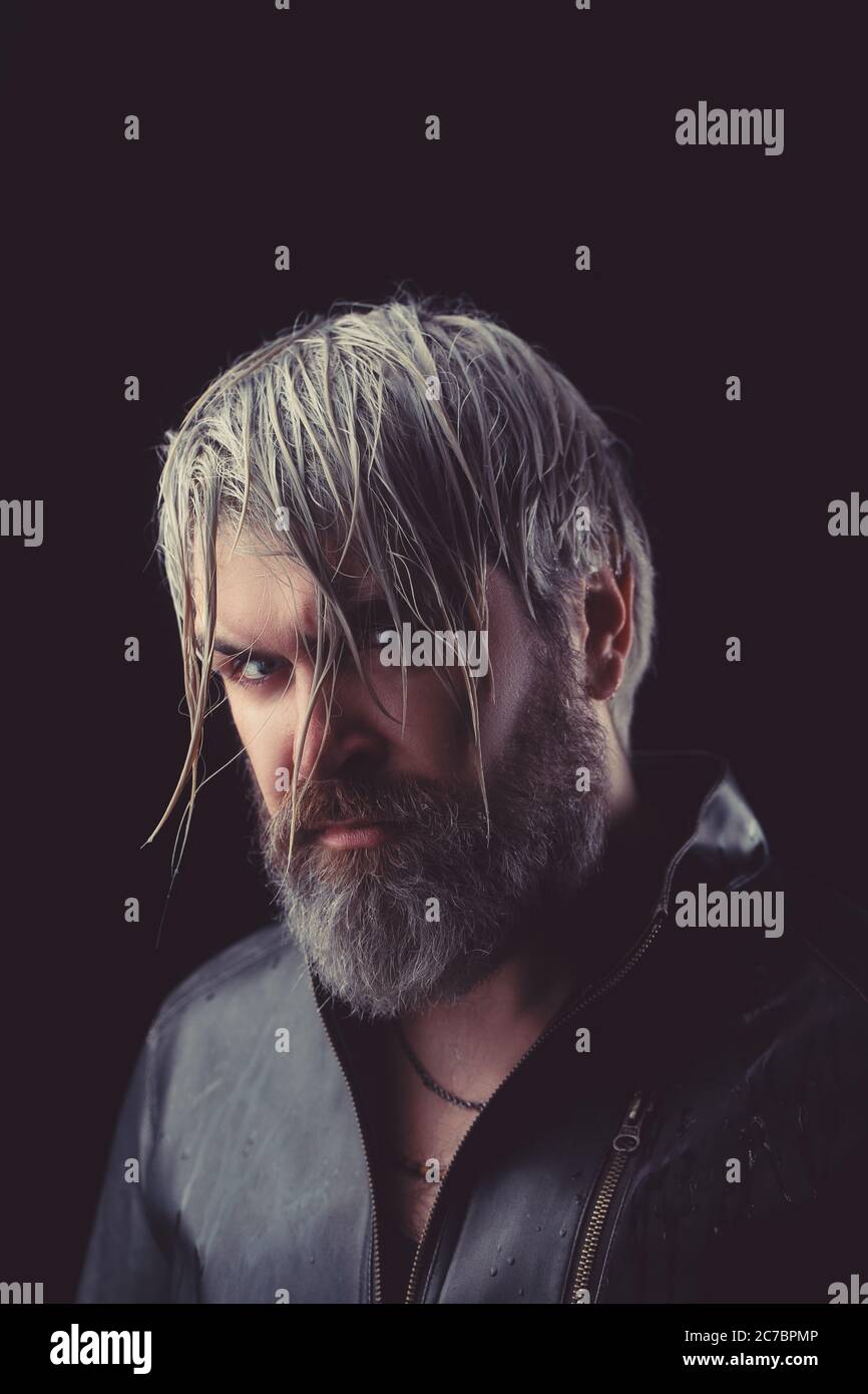Handsome brutal man on the studio shoot in leather jacket. Stock Photo