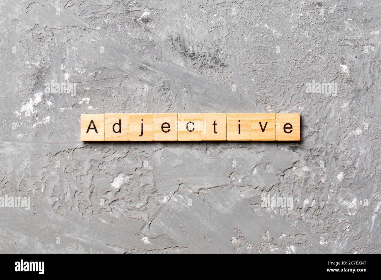 adjective word written on wood block. adjective text on cement table
